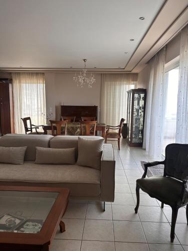 a living room with a couch and a table at Spacious apartment with top view in Nea Makri