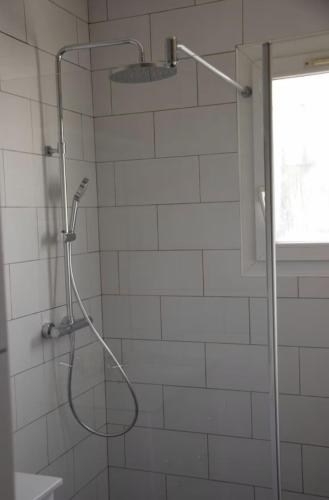 une douche avec pommeau de douche dans une salle de bain dans l'établissement La gujanaise, à Gujan-Mestras