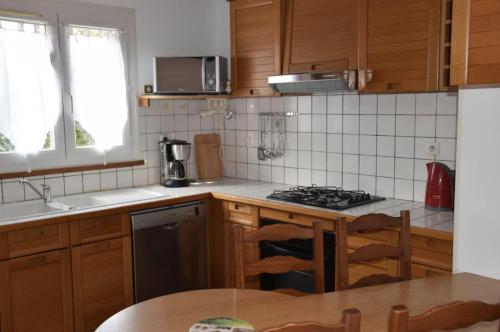 une cuisine avec des armoires en bois et un four à plaques de cuisson dans l'établissement La gujanaise, à Gujan-Mestras