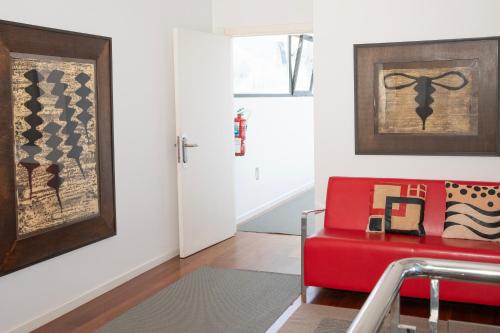 a living room with a red couch and a door at Hotel Arbe in Mutriku