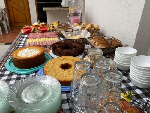 a table topped with plates and cakes and other desserts at Pousada Sagrada Devoção in Aparecida