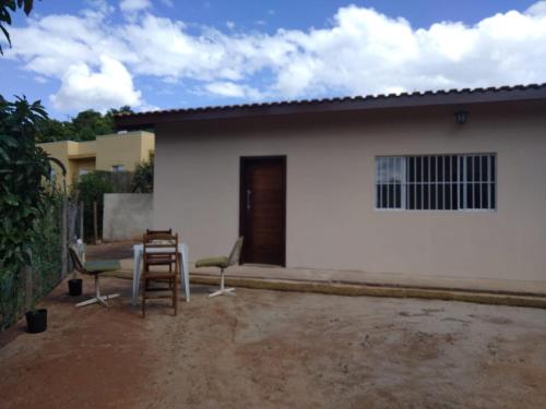 a white house with two chairs and a table at Chalé Recanto na Montanha in Serra Negra