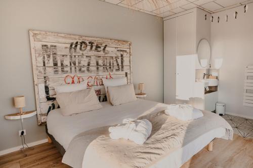a bedroom with a large white bed with towels on it at La Villa de Pen ar Menez terre & mer avec spa in Plouider
