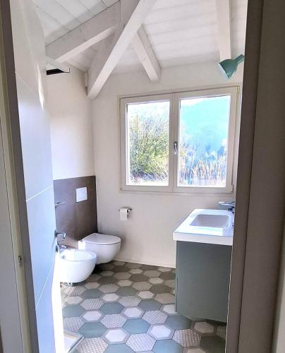 a bathroom with a toilet and a sink and a window at Colle Gelso in Cesena