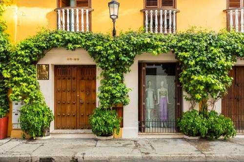 a building with a bunch of ivy growing on it at Hotel Boutique Casa del Coliseo in Cartagena de Indias