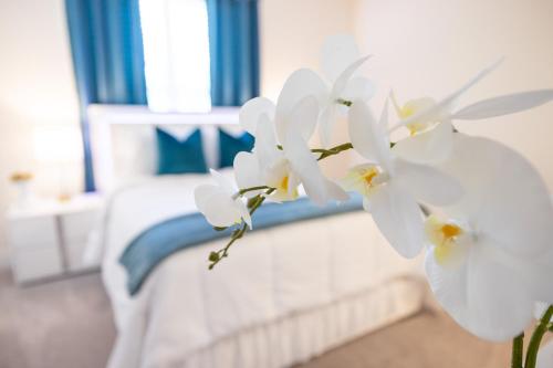 a bed with white flowers in a bedroom at Allstar Luxury Home LLC in Durham