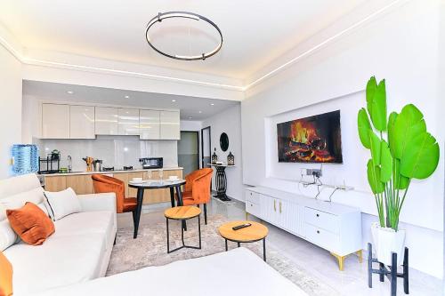 a living room with a white couch and a table at Riara One Residency, Kilimani in Nairobi