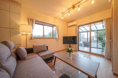 a living room with a couch and a table at ルダス野田 in Kamegawa