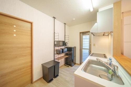 a kitchen with a sink and a microwave at ルダス野田 in Kamegawa