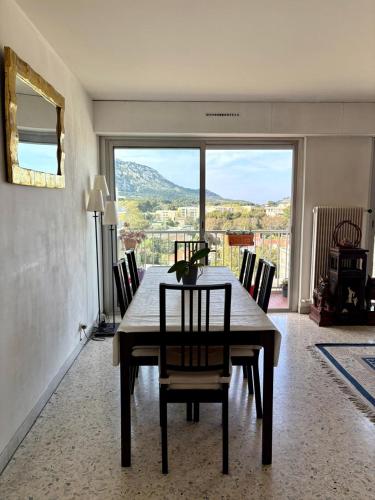 une salle à manger avec une table et des chaises et une grande fenêtre dans l'établissement LES ISLES Panoramic Sea View, à Marseille