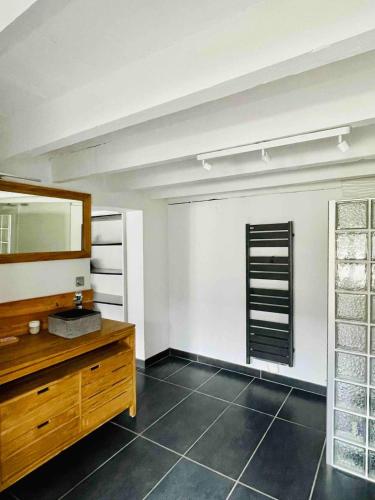 La salle de bains est pourvue d'un miroir et d'une commode en bois. dans l'établissement Cozy house with hot tub and tiki bar, à Capbreton