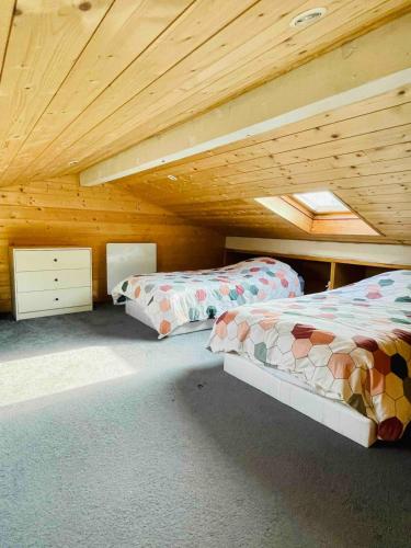 deux lits dans une chambre avec un plafond en bois dans l'établissement Cozy house with hot tub and tiki bar, à Capbreton