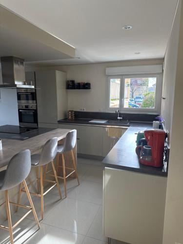 - une cuisine avec un comptoir et quelques chaises dans l'établissement Appartement Boileau, à Metz