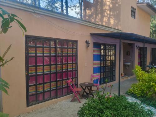 un bâtiment avec des portes en verre colorées et une table dans l'établissement Hostel del bosque, à San Cristóbal de Las Casas