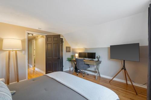 a bedroom with a bed and a desk and a television at Comfy & cozy 4BR minutes to SU, Hospitals, & DT in Syracuse