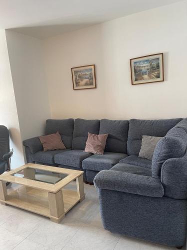 a living room with a blue couch and a coffee table at Amplio apartamento a pie de playa y zona recreativa Rua Carburos 2 in Pontevedra