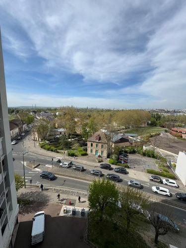 a city street with cars parked in a parking lot at Grand studio lumineux proche gare in Saint-Ouen-lʼAumône