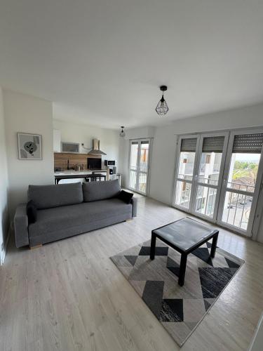 a living room with a couch and a coffee table at Grand studio lumineux proche gare in Saint-Ouen-lʼAumône