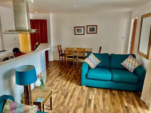 a living room with a blue couch and a table at Stunning spacious Apartment on River Ness in Inverness