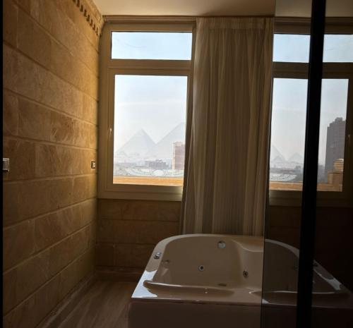 a bathroom with a bath tub and a window at crystal palace pyramids hotel in Cairo