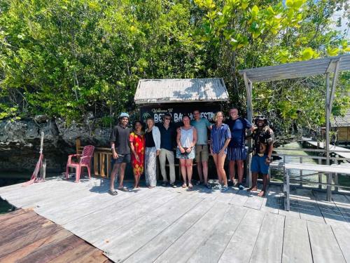 a group of people posing for a picture on a dock at Beser Bay Homestay in Besir