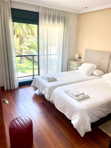 a bedroom with a white bed and a large window at La Casa de la Ría in Collera