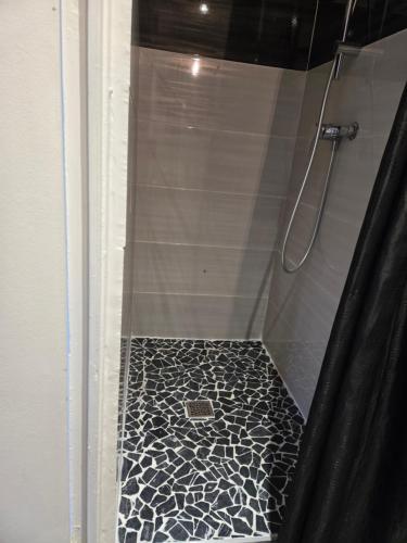 - une douche avec du carrelage noir et blanc dans l'établissement Studio RivaHome, à Ouistreham