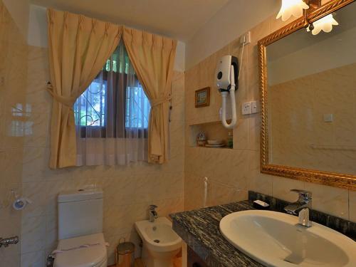 a bathroom with a sink and a toilet and a mirror at Emel Boutique in Negombo