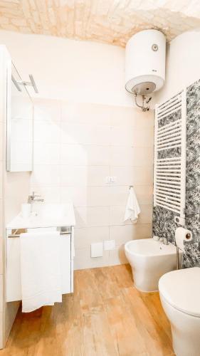 a white bathroom with a sink and a toilet at Dimora Fiore Guest House in Martina Franca