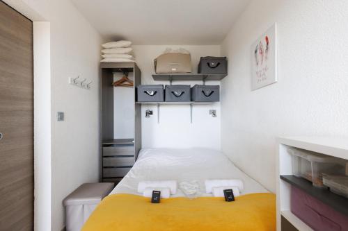 Cette petite chambre comprend un lit avec des draps jaunes. dans l'établissement Les Coteaux Du Préconil YourHostHelper, à Sainte-Maxime