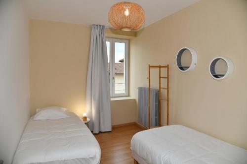 a bedroom with two beds and a window at Domaine des Étoiles - Gîtes in Gillonnay
