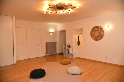 a living room with a chandelier and two mats on the floor at Domaine des Étoiles - Gîtes in Gillonnay