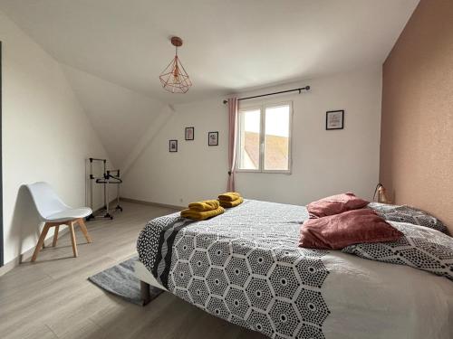 une chambre avec un lit, une chaise et une fenêtre dans l'établissement Le Havre Normand Villa piscine intérieure terrain de pétanque baby foot, ping pong, table de poker, billard, terrasse aménagée, jardin, proche plages du débarquement entre Caen et Bayeux, à Coulombs
