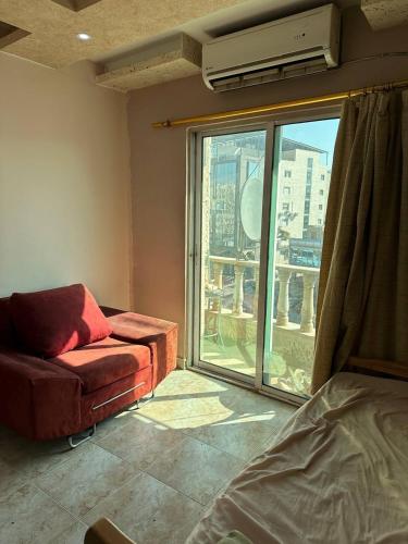 a living room with a couch and a large window at استوديو صويلح studio sweileh 2 in Amman