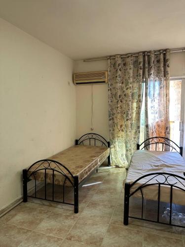 a room with two beds and a window at استوديو صويلح studio sweileh 2 in Amman