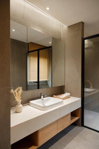 a bathroom with a sink and a mirror at Sendoro Retreat in Láng Lớn