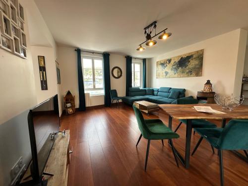 - un salon avec une table et des chaises vertes dans l'établissement Captain YOO - Terre Neuvas - Suite du capitaine sur le port, à Fécamp