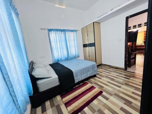 a bedroom with a bed and a large window at Green Haven in Mananthavady
