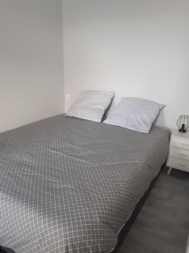 une chambre avec un lit avec deux oreillers dessus dans l'établissement GITE Le Petit Doué, à Saint-Malo-du-Bois