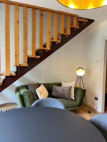 a living room with a green couch and stairs at Residence Dromaè in Ledro