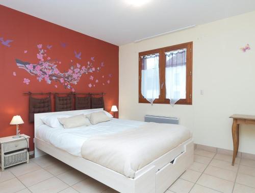 a bedroom with a white bed and a red wall at Domaine des Étoiles - Gîtes in Gillonnay