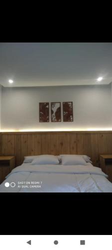 a bedroom with a bed with two pictures on the wall at Green cottage in Labuan Tring
