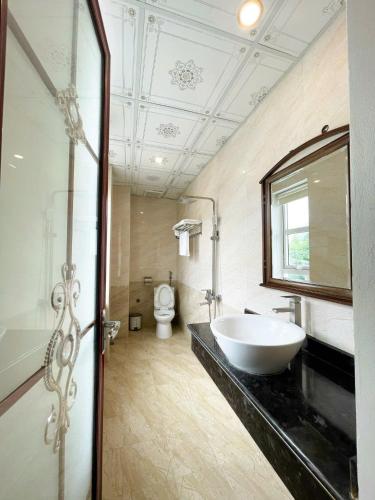 a bathroom with a sink and a toilet at FULL HOUSE Hotel in Ðong Thon