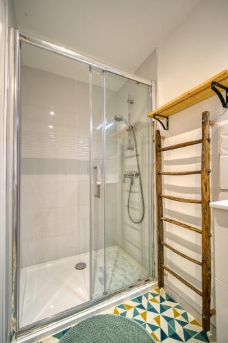 une douche avec une porte vitrée dans une salle de bain dans l'établissement Maison Michonières - Gîte 3 étoiles - 8 personnes, à Miribel