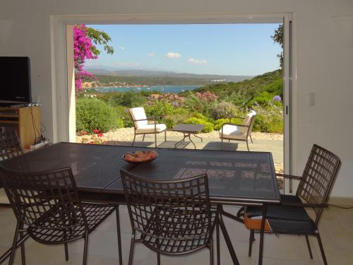 une salle à manger avec une table et des chaises et une grande fenêtre dans l'établissement Boccamanza, à Bonifacio