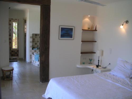 une chambre avec un lit blanc et un escalier dans l'établissement Boccamanza, à Bonifacio