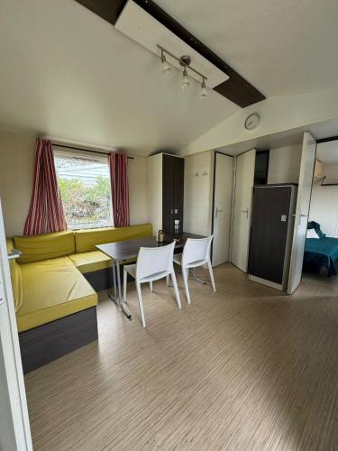 Cette chambre comprend un canapé, une table et des chaises. dans l'établissement Camping logement entier 3 chambres, à La Roque-dʼAnthéron