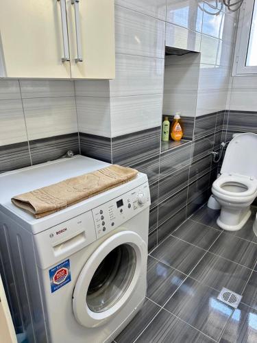 a washing machine in a bathroom with a toilet at Apartment for rent Piqeras, Sarande in Piqeras