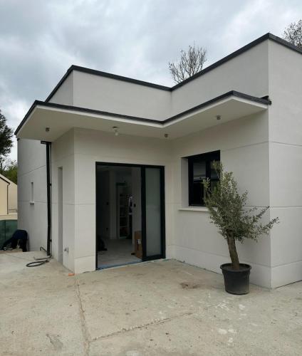 une maison blanche avec sa porte ouverte dans l'établissement New Architect-Designed Villa, à Champs-sur-Marne