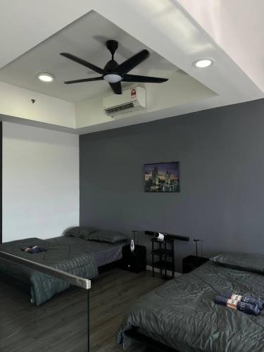 a bedroom with two beds and a ceiling fan at 3volution Stays in Petaling Jaya